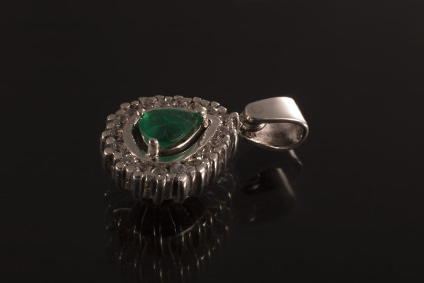 经典吊坠项链与钻石和祖母绿的背景黑色，珠宝与宝石图片下载