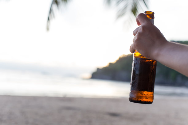 在海滩上喝啤酒。图片下载