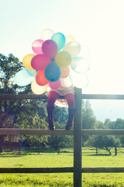 女孩的腿和彩色气球在阳光的光线素材图片