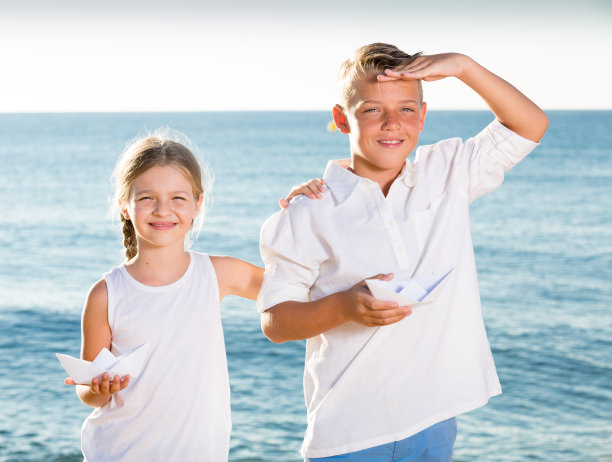 男孩和女孩在海滩上划船图片下载