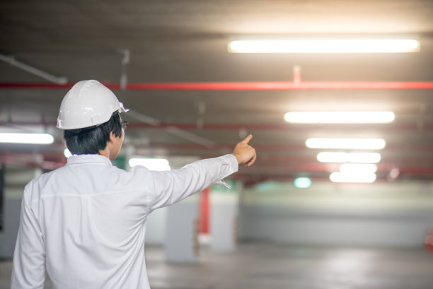 年轻的亚洲工程师或建筑师指着建筑工地图片下载