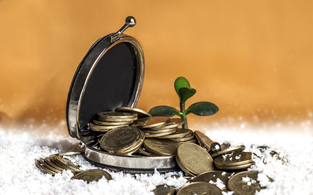 铁钱包与硬币在一个黄色的背景图片下载