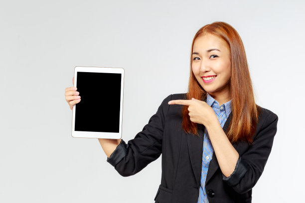 年轻的亚洲快乐商务女性手握数码平板电脑在白色的背景图片下载