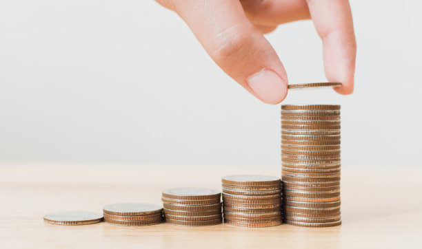 存钱和投资是成长成长、富有和可持续发展的未来概念，男人或女人的手放硬币叠步成长成长金融素材图片
