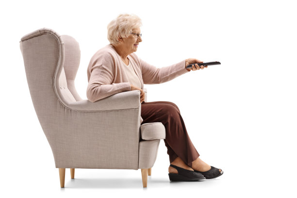 坐在扶手椅上的老妇人在换电视频道图片下载