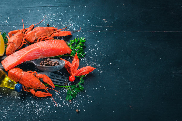 海鲜。呕吐鱼、龙虾、鲑鱼。在木制的背景上。前视图。文本的空闲空间。图片下载