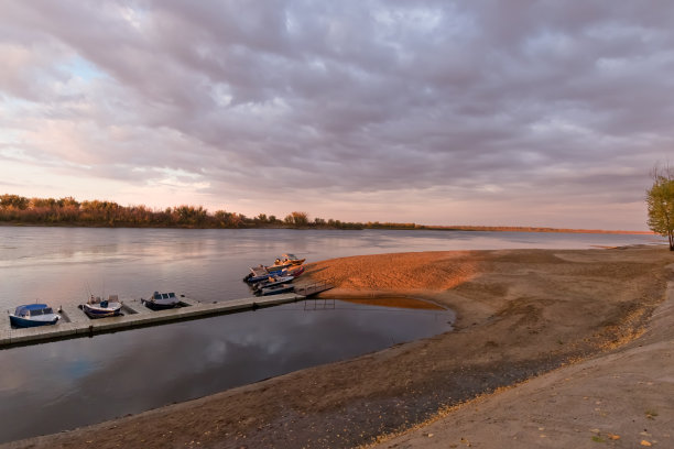 日落时分，沙滩上摩托艇停靠的码头图片下载