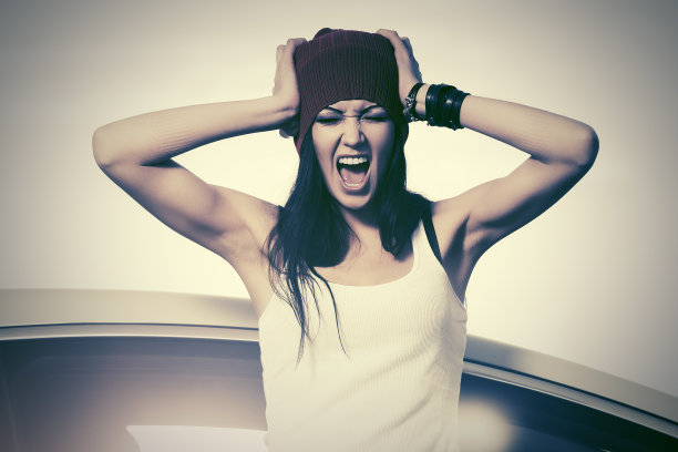 穿着t恤的愤怒时尚女人在她的车旁边大叫图片下载