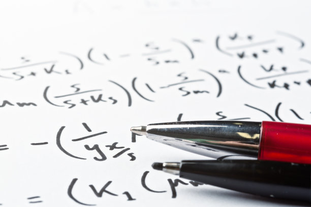 特写的两支笔放在一个复杂的手写方程式上图片下载