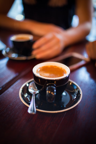 近距离观察两名妇女在开会时桌上的双倍浓缩咖啡图片下载