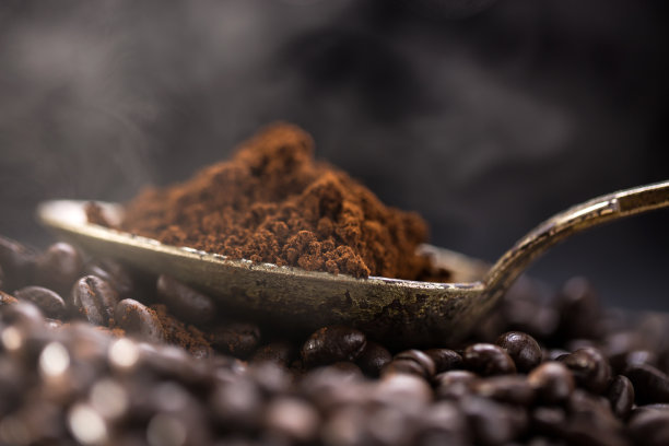 烤好的咖啡倒进一个旧银匙里。图片下载