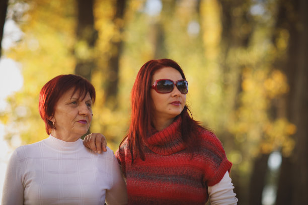 年长的女人和成年的女儿在秋天公园图片下载