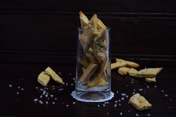 家里做的脆饼干放在玻璃杯里，背景是黑色。图片下载