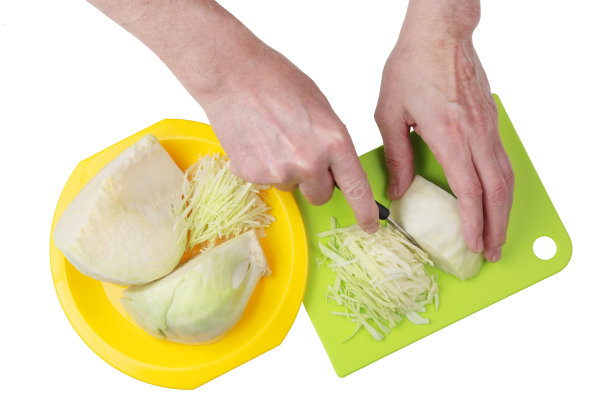 要煮出美味的蔬菜汤，卷心菜必须用手和锋利的刀切碎。图片下载