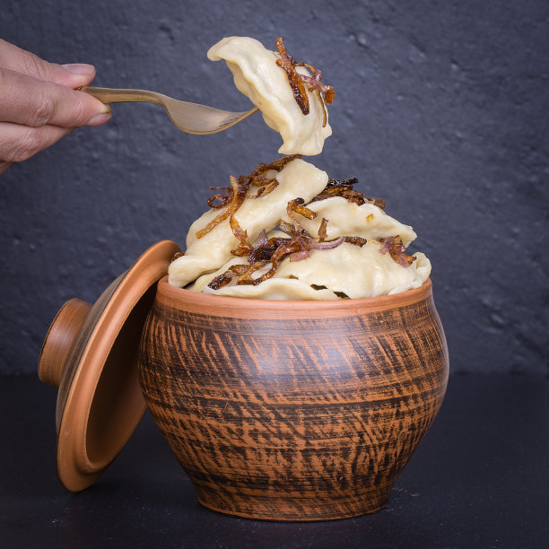 乌克兰菜-瓦伦尼基或土豆泥饺子或软干酪在陶罐，靠近图片下载