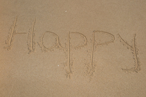 在沙滩的沙子上写着“快乐”图片下载