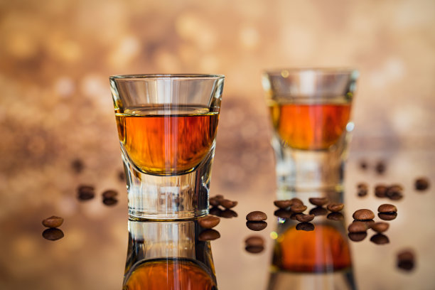 干邑或利口酒，咖啡豆和香料放在玻璃桌子上。图片下载