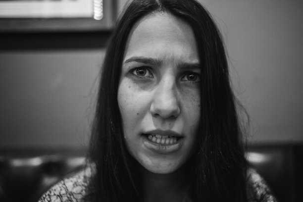 坐在咖啡厅沙发上的时尚女孩。照片黑白风格。图片下载