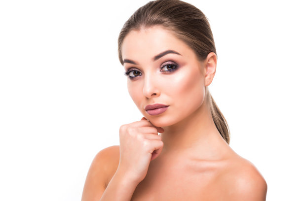 漂亮的年轻褐发女人的脸肖像。美丽的模特女孩，明亮的眉毛，完美的化妆，红色的嘴唇，触摸她的脸。性感女士的化妆派对孤立的白色背景图片下载