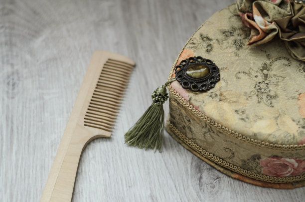 珠宝首饰盒。挂毯的首饰盒和木制背景上的梳子图片下载
