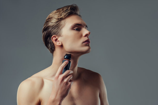 灰色背景上的英俊男子。图片下载