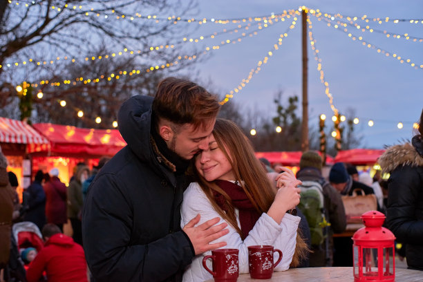 一对快乐的年轻夫妇在圣诞市场素材图片