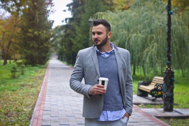 年轻性感的家伙漫步在秋天，夏天的公园。人在喝咖啡，人在喝茶。欧洲的乡村。设计素材照片图片下载