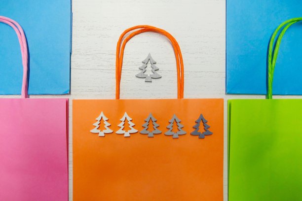 一排排五颜六色的纸袋上面放着小树图片下载