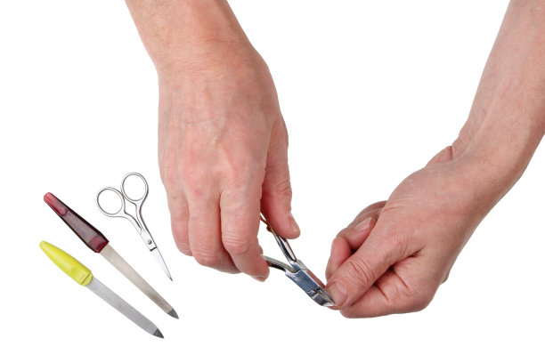 一位贫穷的农村老人用镊子和剪刀剪手指上的指甲。图片下载
