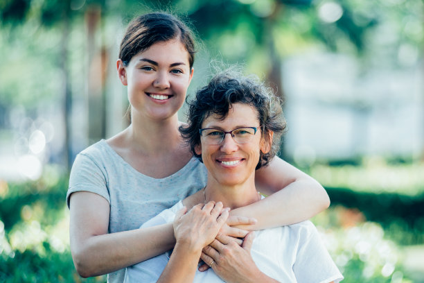 快乐的十几岁的女儿在公园拥抱妈妈图片下载