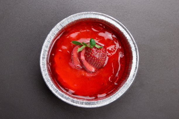 铝制杯子上的草莓迷你派，以朴素的木质蓝色为背景图片下载