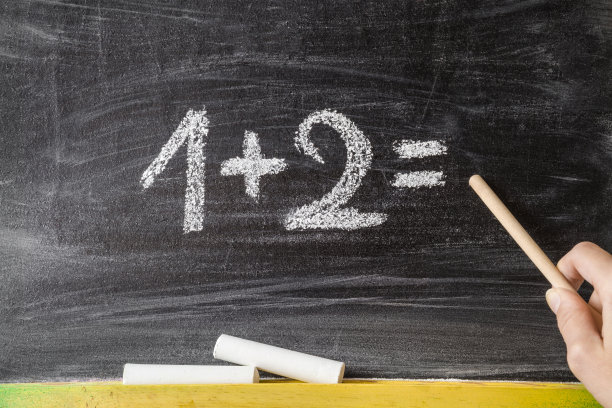 用粉笔画的数字。老师在黑板上给小朋友指指点点教数学。教育的概念。素材图片