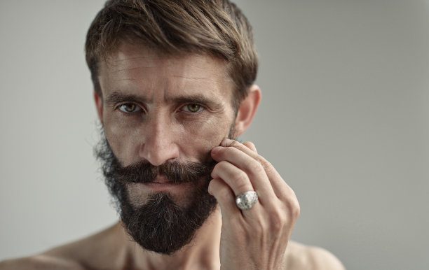 中年英俊男子的肖像与皱纹的脸和胡子在嬉皮风格。图片下载