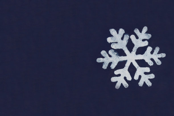 用蜡笔在深蓝色的背景上画了一片白色的雪花。副本的空间。图片下载