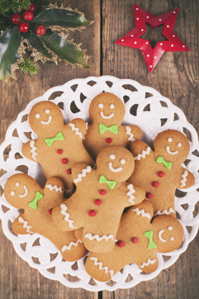 圣诞姜饼男人饼干在复古的盘子在质朴的木桌上素材图片