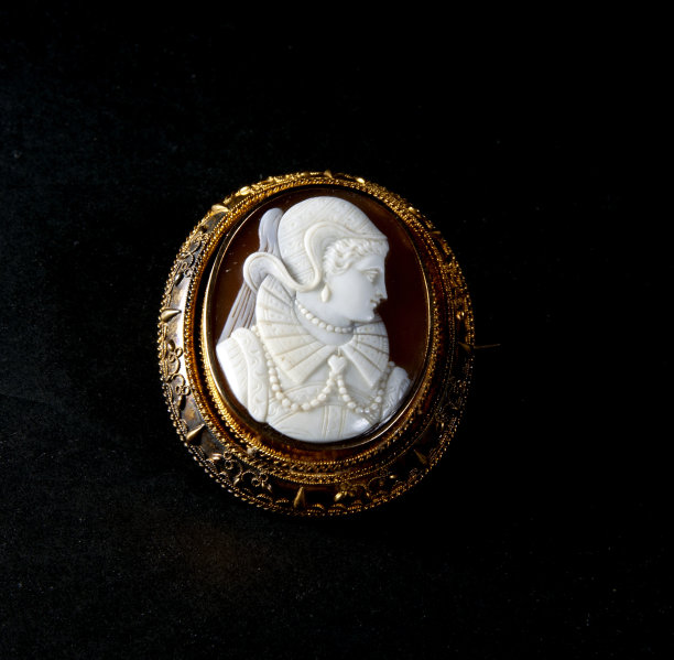 棕色浮雕胸针在金色与白色雕刻的脸图片下载