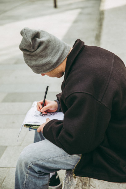 年轻的涂鸦艺术家在城市街道上素描图片下载