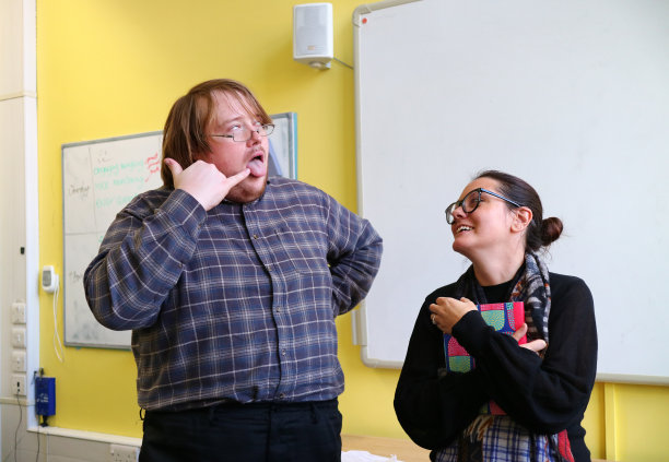 一个做鬼脸逗女人笑的男人图片下载