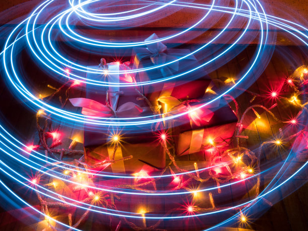 装有圣诞礼物的盒子，有花环，有星星效果的灯和由灯光绘制的圆形痕迹图片下载
