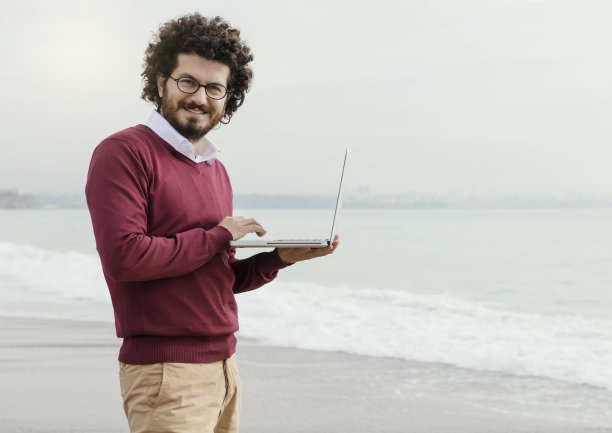 商人在海滩上使用笔记本电脑图片下载