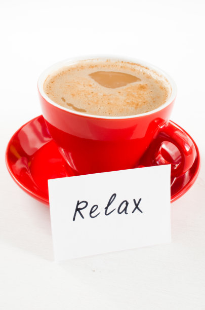 一杯红卡布奇诺和笔记放松在轻乡村桌子。图片下载