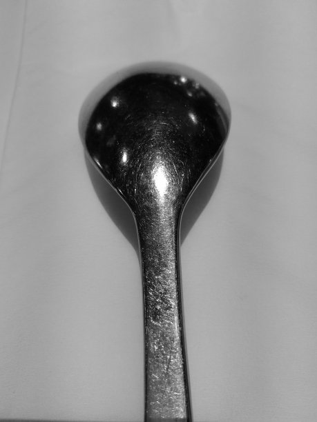 厚厚的银匙放在白纸上，黑白相间图片下载