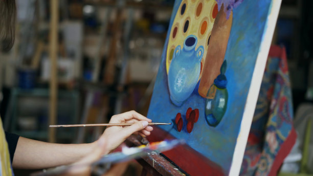 特写的艺术家女人与画笔画在画布上的静物画在艺术课图片下载