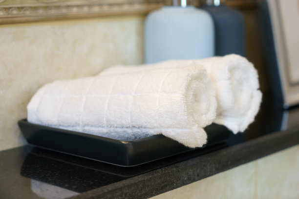 浴室里有两条白色毛巾和一瓶肥皂图片下载