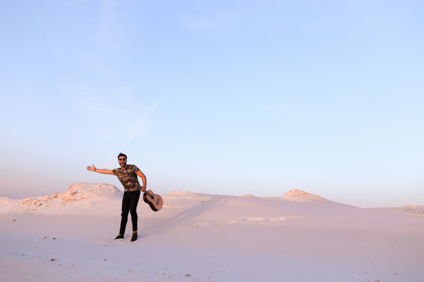 被沙漠美景所启发弹吉他的阿拉伯男子图片下载