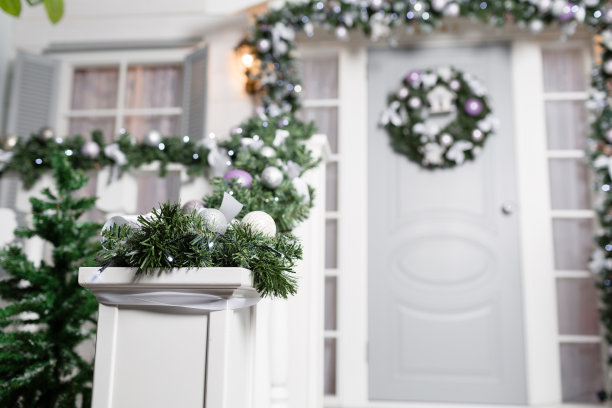 房屋入口为节日装饰。圣诞装饰。栏杆上用冷杉树枝编成的花环和灯图片下载