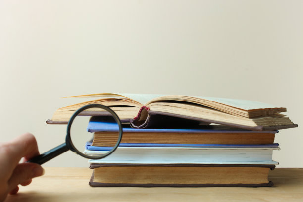 一堆书和一个放大镜图片下载