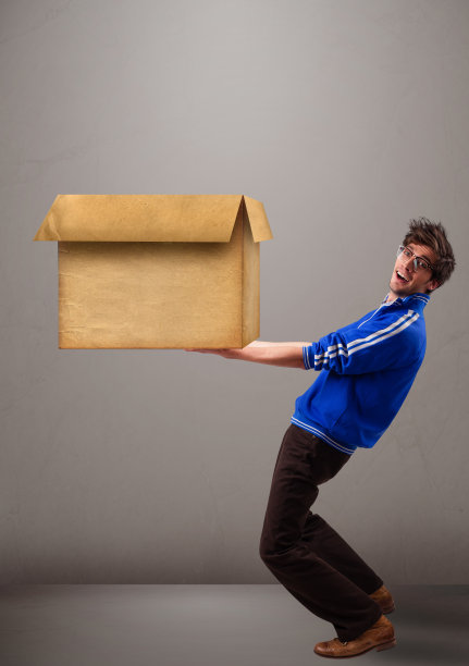 一个表情严肃的人，手里拿着一个棕色空纸板箱图片下载