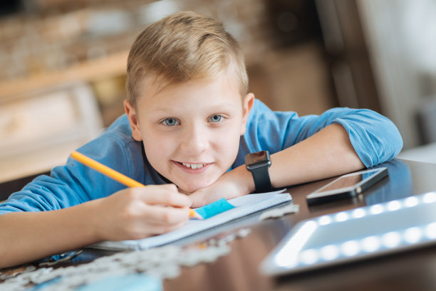 开朗积极的男孩用铅笔写字图片下载