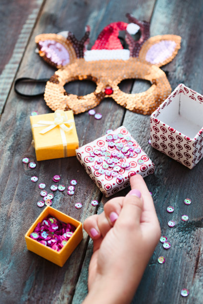 近距离拍摄的女性手装饰圣诞驯鹿面具与亮片以下diy的想法图片下载